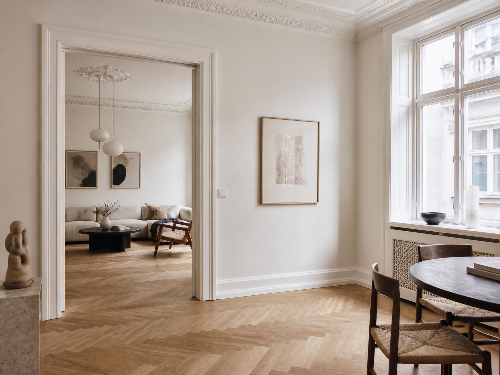 Cream living room with oak herringbone floor and tall windows