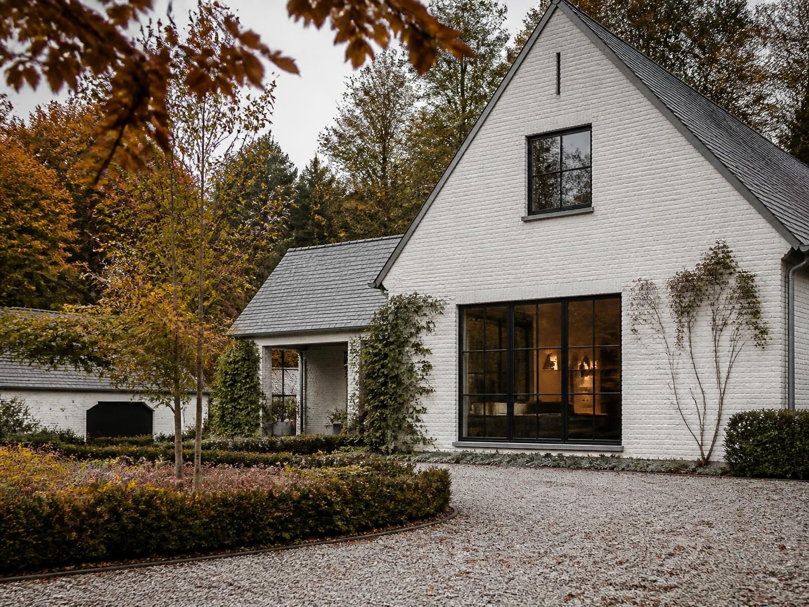 Whitewashed brick villa with slate roof and gravel drive